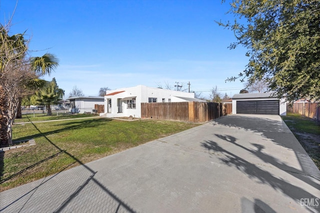 view of front of home featuring a garage, an outdoor structure, and a front yard