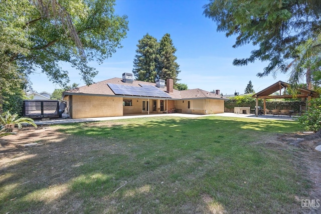 6801 Weldon Ave, Bakersfield, CA 93308 - rear view of house with a gazebo, a patio area, roof mounted solar panels, and a lawn