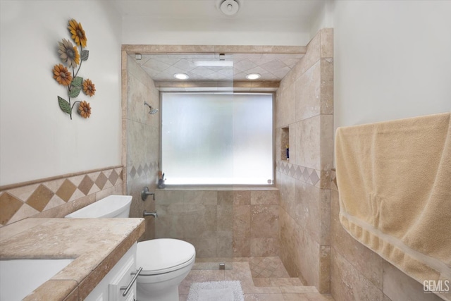 6801 Weldon Ave, Bakersfield, CA 93308 - bathroom with tile walls, toilet, a tile shower, vanity, and a wainscoted wall