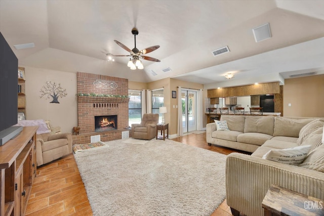 6801 Weldon Ave, Bakersfield, CA 93308 - living area with a ceiling fan, vaulted ceiling, a brick fireplace, and light wood-style flooring