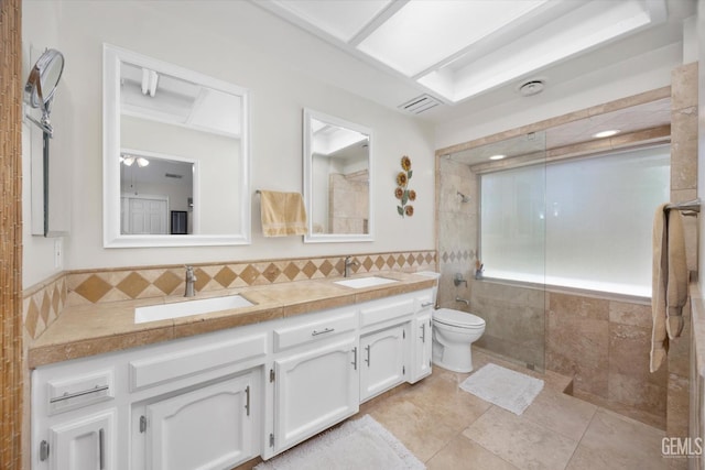 6801 Weldon Ave, Bakersfield, CA 93308 - bathroom with tiled shower, double vanity, toilet, tile patterned flooring, and tile walls