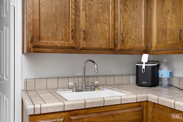 6801 Weldon Ave, Bakersfield, CA 93308 - kitchen with a sink, brown cabinetry, and light countertops