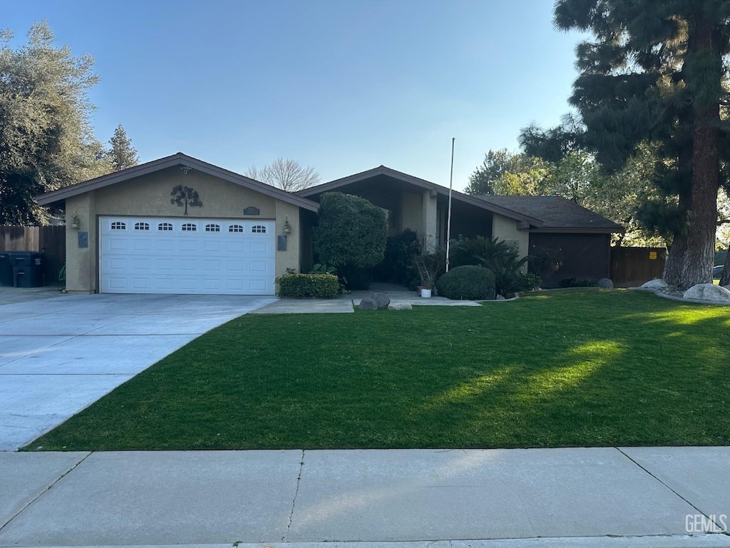 ranch-style home featuring a garage and a front lawn