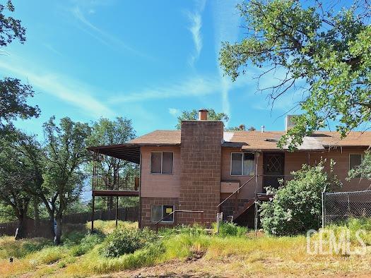 411 Old State Rd, Wofford Heights, CA 93285 - rear view of property featuring fence and a chimney