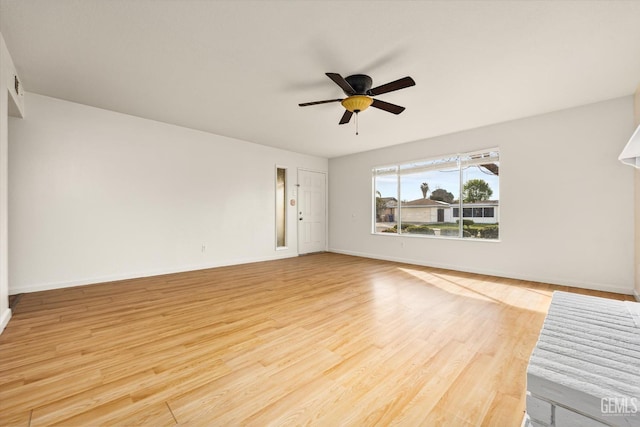 unfurnished living room featuring light wood-type flooring, ceiling fan, and baseboards