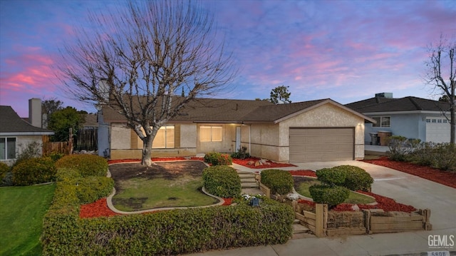 ranch-style home with a garage, concrete driveway, and stucco siding