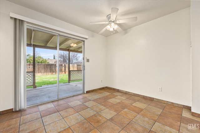 spare room featuring ceiling fan, light tile patterned flooring, and baseboards