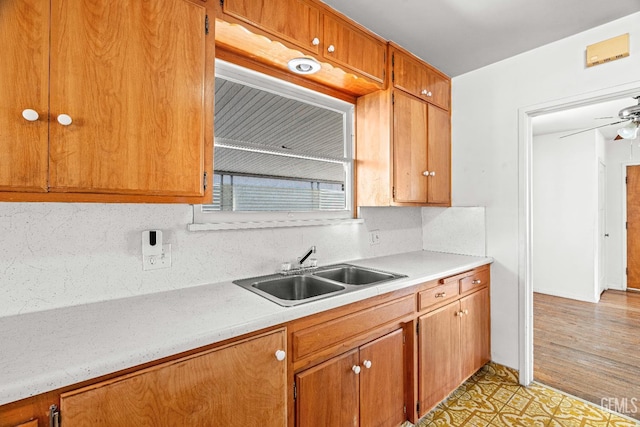 102 Wetherley Dr, Bakersfield, CA 93309 - kitchen featuring a sink, light countertops, decorative backsplash, and brown cabinetry