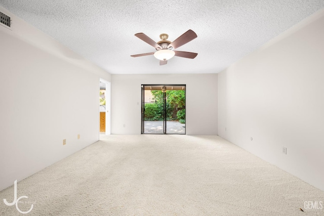 spare room featuring a ceiling fan, carpet, and a textured ceiling