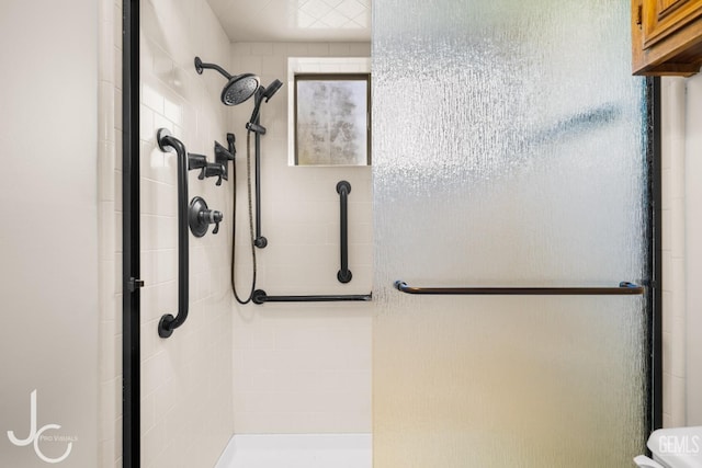bathroom with toilet and a stall shower