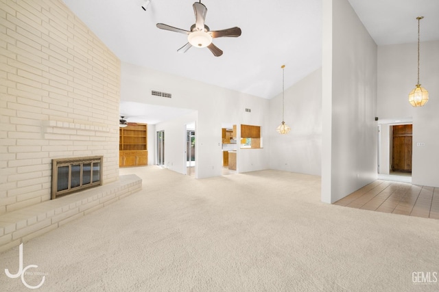 unfurnished living room with a ceiling fan, carpet, a fireplace, and high vaulted ceiling
