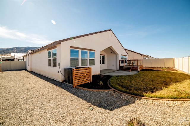 rear view of house featuring a patio area, a deck, and a lawn