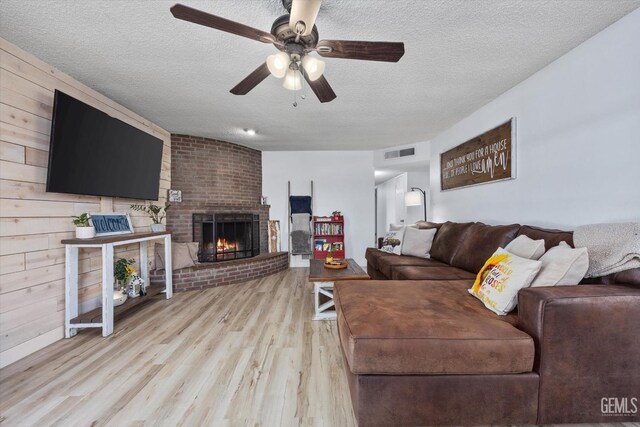 5906 Ronald Way, Bakersfield, CA 93308 - living area featuring light wood-style floors, a ceiling fan, a textured ceiling, and a brick fireplace