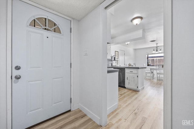 5906 Ronald Way, Bakersfield, CA 93308 - entryway with light wood finished floors, a chandelier, and a textured ceiling