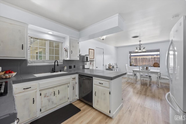 5906 Ronald Way, Bakersfield, CA 93308 - kitchen featuring freestanding refrigerator, dishwashing machine, a peninsula, tile counters, and tasteful backsplash