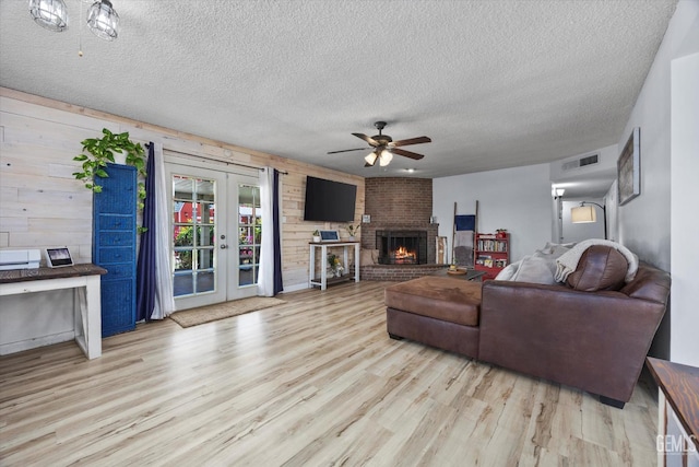 5906 Ronald Way, Bakersfield, CA 93308 - living room with a textured ceiling, a ceiling fan, wood finished floors, french doors, and a brick fireplace