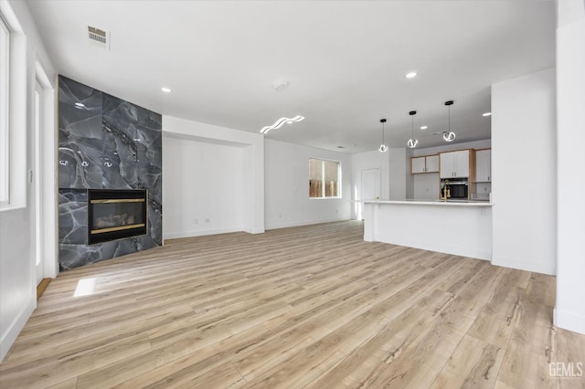 unfurnished living room featuring a fireplace and light wood-type flooring