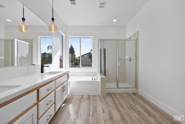 bathroom featuring wood-type flooring, shower with separate bathtub, and vanity