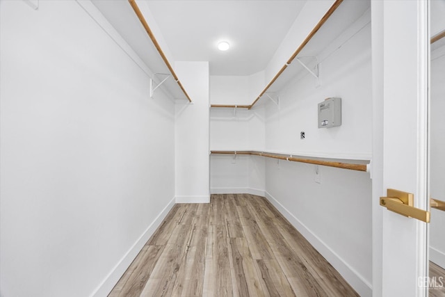 walk in closet with light hardwood / wood-style flooring