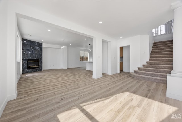 unfurnished living room with a healthy amount of sunlight, a fireplace, and light hardwood / wood-style floors