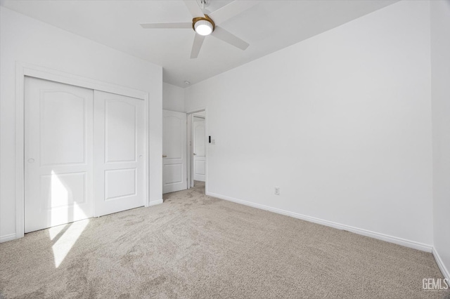 unfurnished bedroom featuring light colored carpet, a closet, and ceiling fan