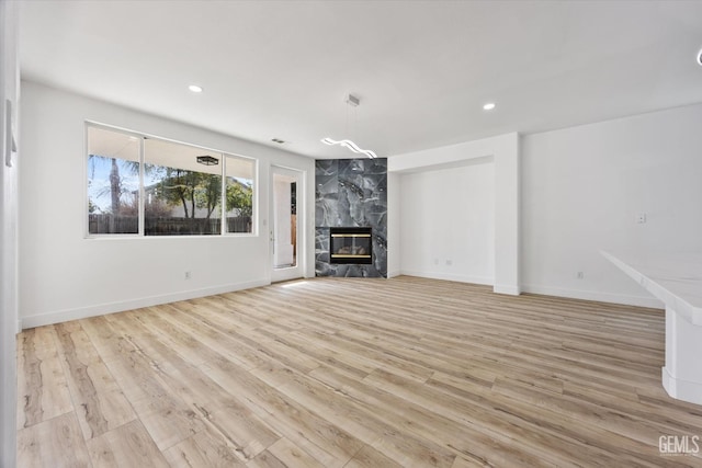 unfurnished living room with a fireplace and light wood-type flooring