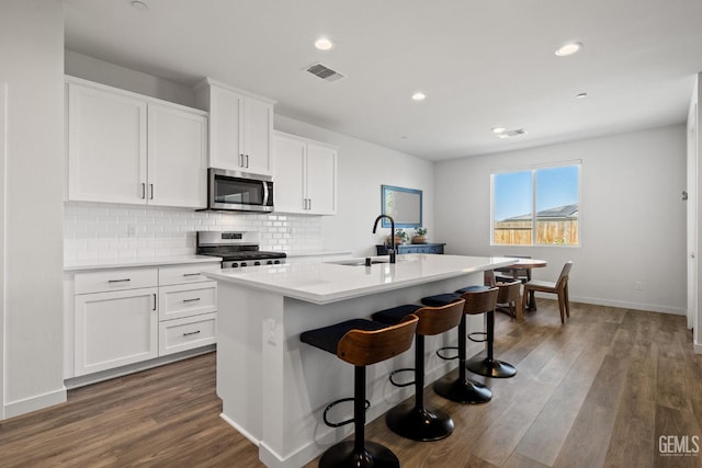 713 Winooski Ct, Bakersfield, CA 93314 - kitchen featuring appliances with stainless steel finishes, an island with sink, dark wood-style floors, recessed lighting, and tasteful backsplash