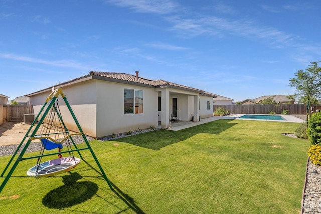 713 Winooski Ct, Bakersfield, CA 93314 - rear view of house with a tile roof, a fenced backyard, stucco siding, a patio area, and a playground