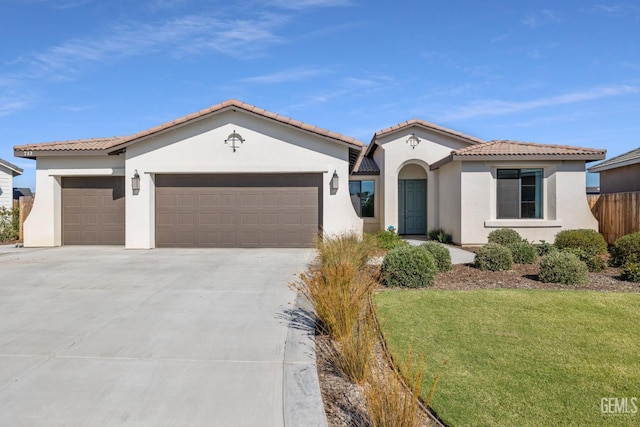 713 Winooski Ct, Bakersfield, CA 93314 - mediterranean / spanish home featuring an attached garage, stucco siding, driveway, and a front lawn