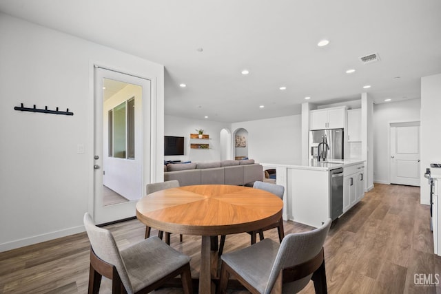 713 Winooski Ct, Bakersfield, CA 93314 - dining space with arched walkways, wood finished floors, and recessed lighting