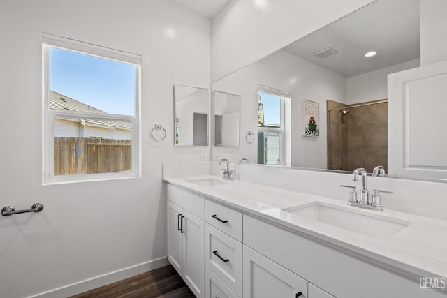 713 Winooski Ct, Bakersfield, CA 93314 - bathroom featuring double vanity, wood finished floors, and tiled shower