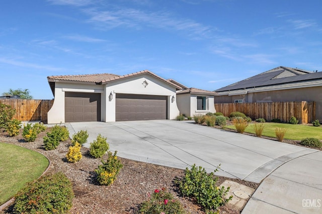 713 Winooski Ct, Bakersfield, CA 93314 - view of front of property featuring a garage, driveway, a tile roof, and stucco siding