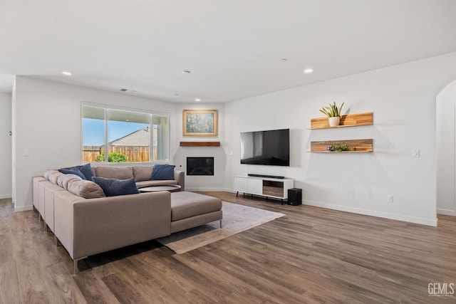 713 Winooski Ct, Bakersfield, CA 93314 - living area with wood finished floors, recessed lighting, a glass covered fireplace, and arched walkways
