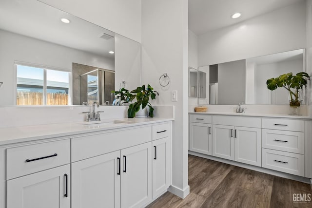 713 Winooski Ct, Bakersfield, CA 93314 - full bathroom with two vanities, a shower stall, wood finished floors, and recessed lighting