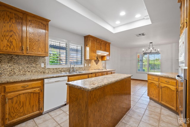 631 Faversham Way, Bakersfield, CA 93311 - kitchen with white dishwasher, a sink, under cabinet range hood, decorative backsplash, and light tile patterned floors
