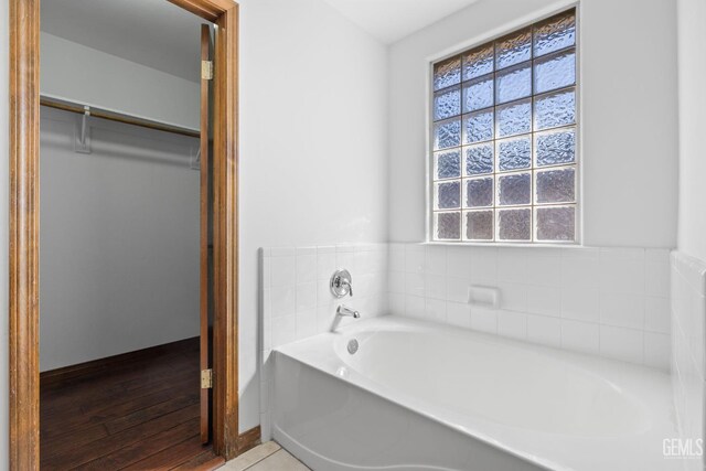 631 Faversham Way, Bakersfield, CA 93311 - bathroom with a garden tub, baseboards, and wood finished floors