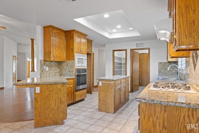 631 Faversham Way, Bakersfield, CA 93311 - kitchen featuring white appliances, a sink, a peninsula, extractor fan, and a center island