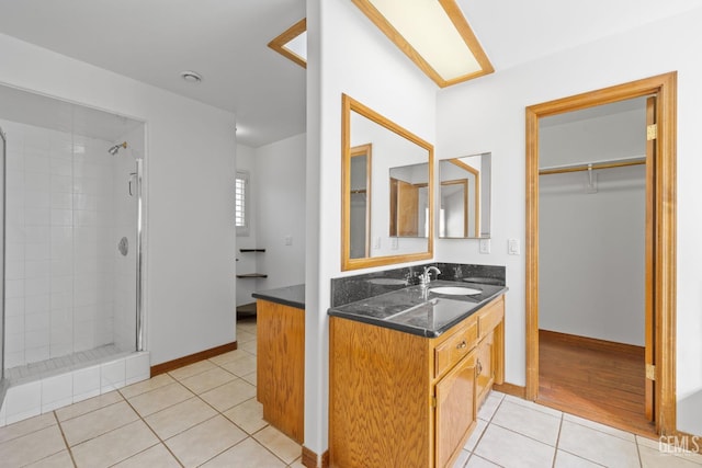 631 Faversham Way, Bakersfield, CA 93311 - bathroom with vanity, tile patterned floors, a stall shower, a spacious closet, and baseboards