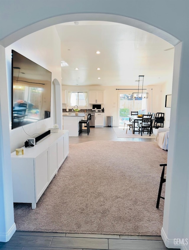 7303 Wild Mustang Dr, Bakersfield, CA 93311 - living room with arched walkways, recessed lighting, and light wood finished floors