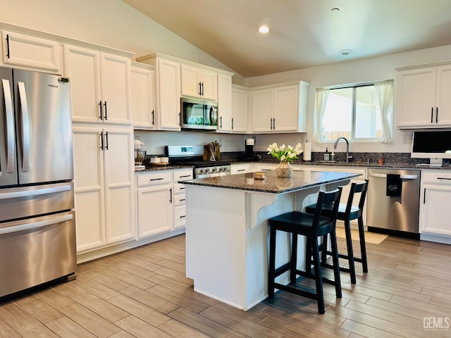 7303 Wild Mustang Dr, Bakersfield, CA 93311 - kitchen featuring stainless steel appliances, vaulted ceiling, light wood-style flooring, white cabinets, and recessed lighting
