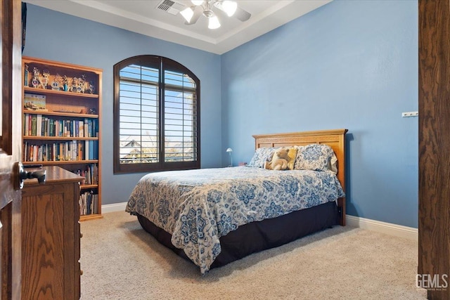 bedroom with visible vents, baseboards, ceiling fan, carpet flooring, and a raised ceiling