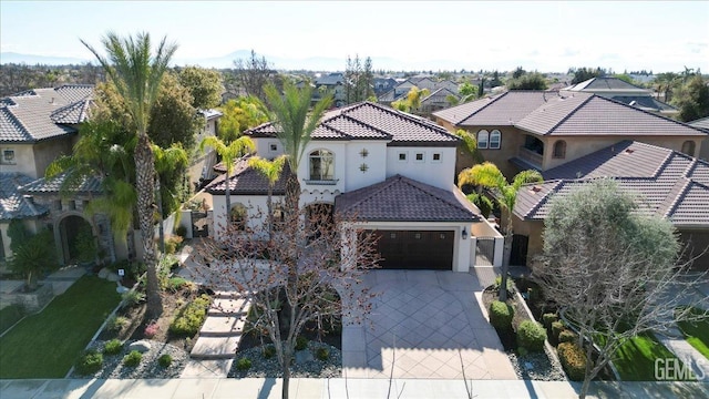 view of front of house featuring stucco siding, concrete driveway, a garage, a tiled roof, and a residential view