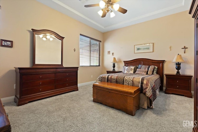 bedroom with a tray ceiling, baseboards, a ceiling fan, and carpet flooring