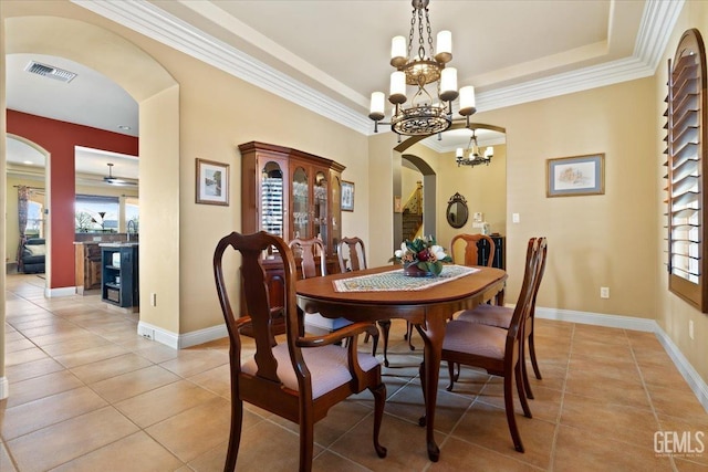 dining room featuring visible vents, a tray ceiling, light tile patterned floors, an inviting chandelier, and arched walkways