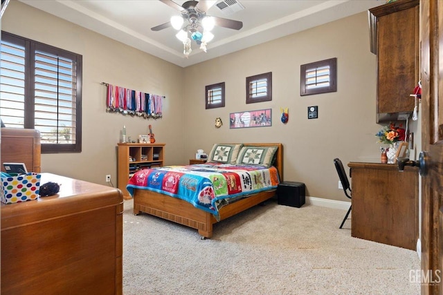 carpeted bedroom with visible vents, a ceiling fan, and baseboards