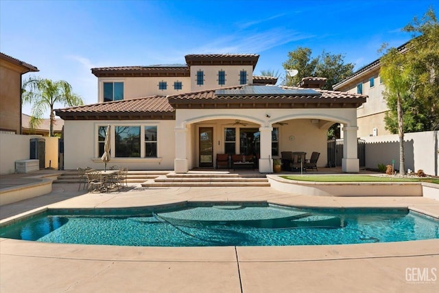 rear view of property featuring a fenced in pool, ceiling fan, a patio, and fence