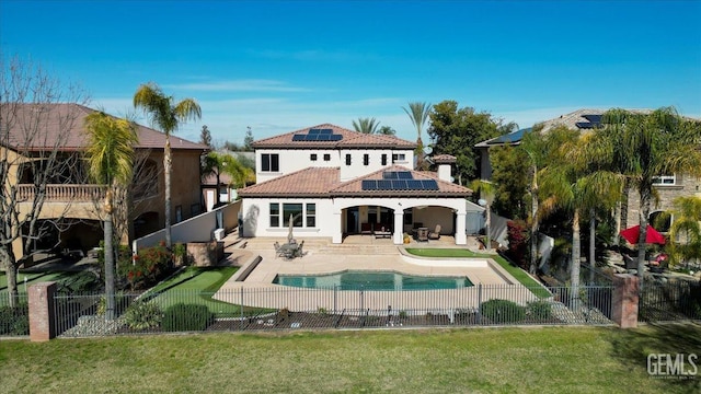 back of property featuring a patio, solar panels, a fenced backyard, and a tiled roof