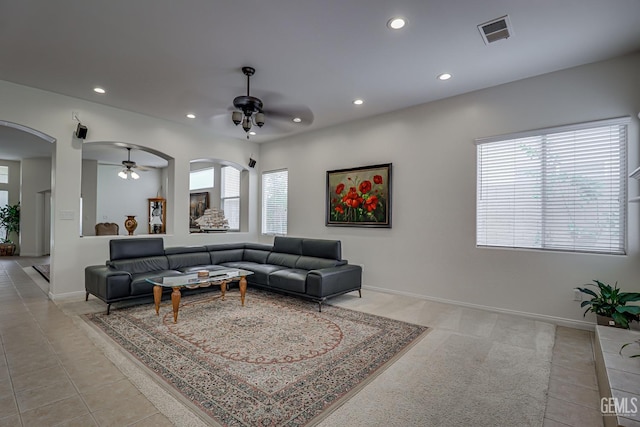 living room featuring ceiling fan, light tile patterned flooring, and a healthy amount of sunlight