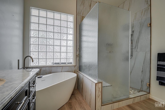 bathroom with hardwood / wood-style floors, vanity, plus walk in shower, and heating unit