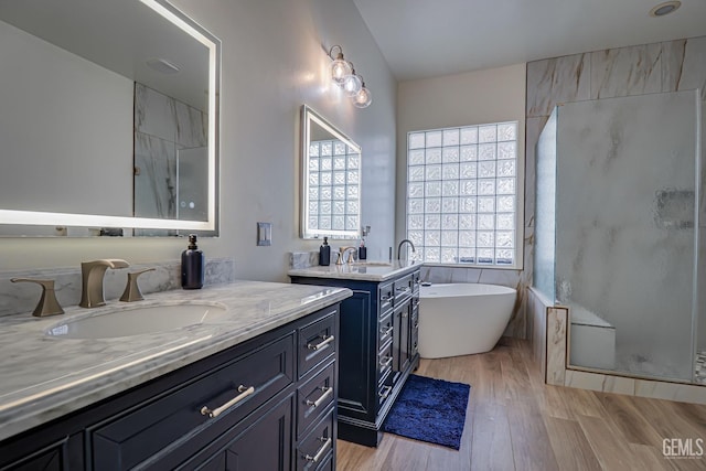 bathroom with hardwood / wood-style flooring, vanity, and independent shower and bath